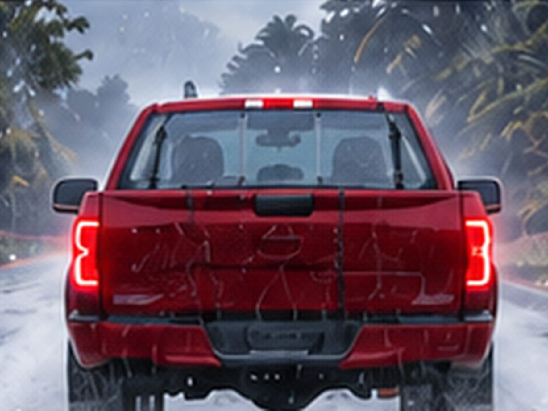 A red pickup with a WHIP guard on each door from behind on a rain-soaked road between dark evergreens